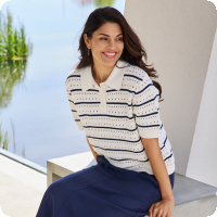 Den h�r stickade tr�jan �r s�songens snyggaste tillskott i garderoben. Med sitt klassiska marinbl�-och-vita randm�nster och det luftiga h�lstickade m�nstret utstr�lar den en tidl�s nautisk charm som aldrig g�r ur mode. Kragen med knappar ger tr�jan en sportig och sofistikerad k�nsla som passar lika bra p� golfbanan som p� en sommarterrass vid havet.